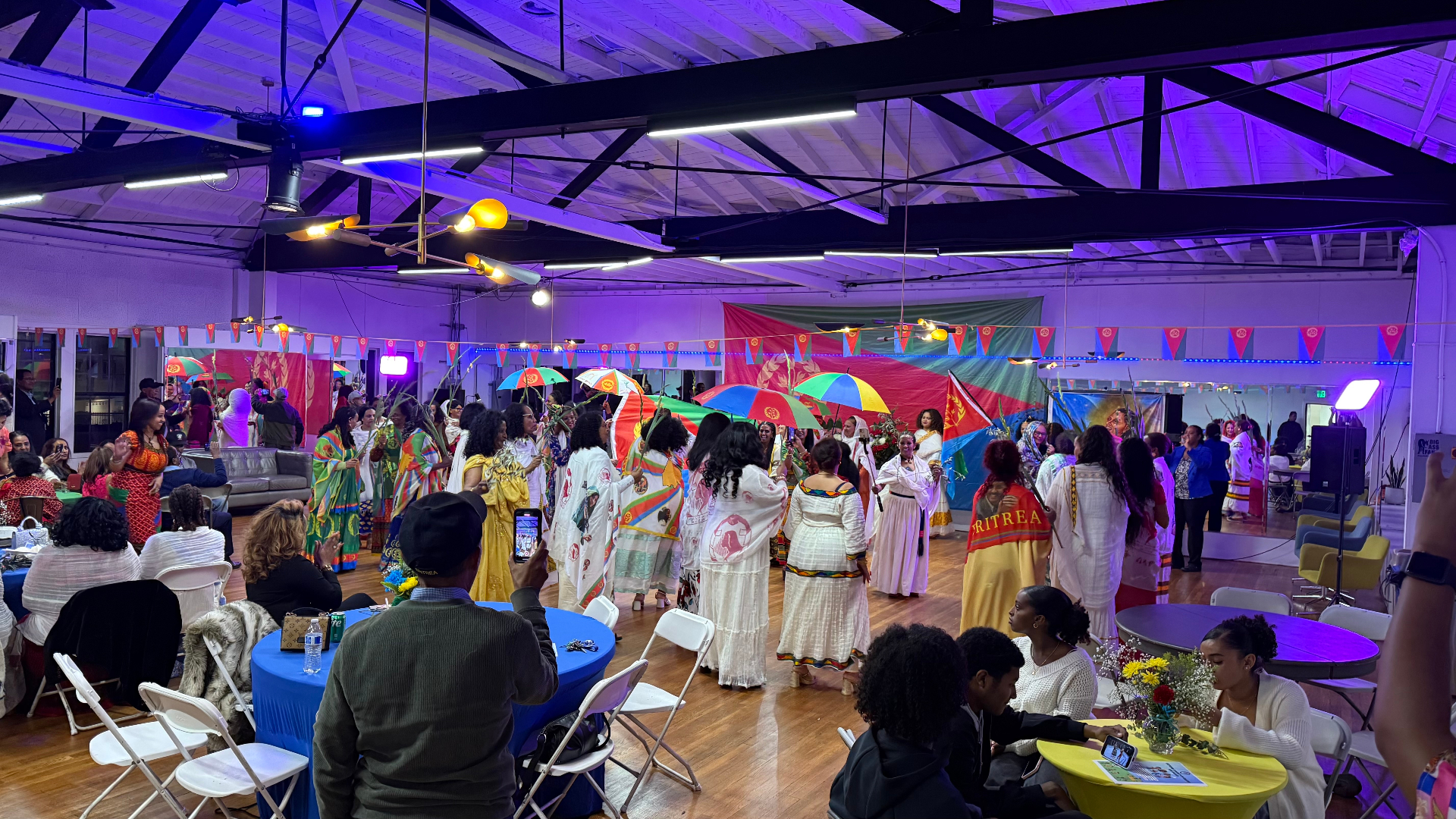 Cultural celebration with guests dancing beneath colorful flags